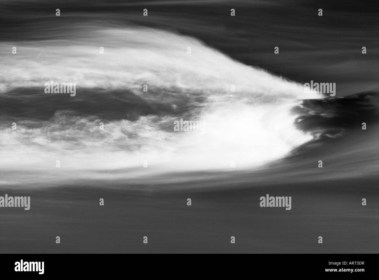 Image of fast flowing water running over a submerged boulder Stock