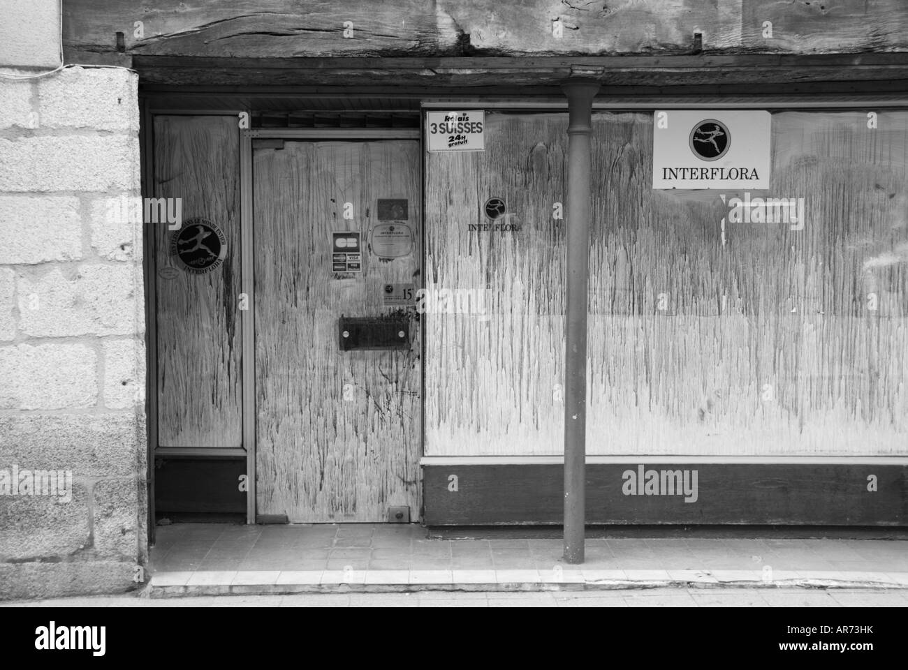 Photo of a shop in Bellac in France The shop is closed for business and the windows are painted over as it awaits its new owners Stock Photo