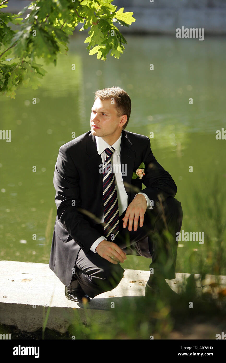A  general view of a groom wearing a suit  looking very apprehensive and thoughtful. Stock Photo