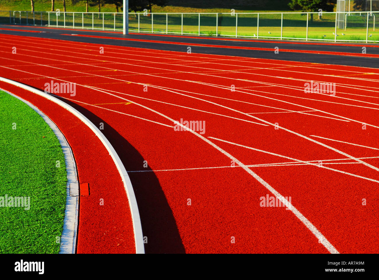 Curving lanes of a red racetrack in a stadium Stock Photo