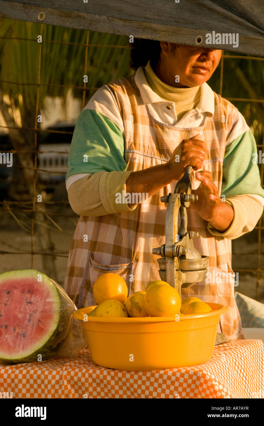 Mexico Nayarit Village of Sayulita near Puerto Vallarta on the Pacific Ocean  Mexican fruit vendor on the beach squeezing orange Stock Photo