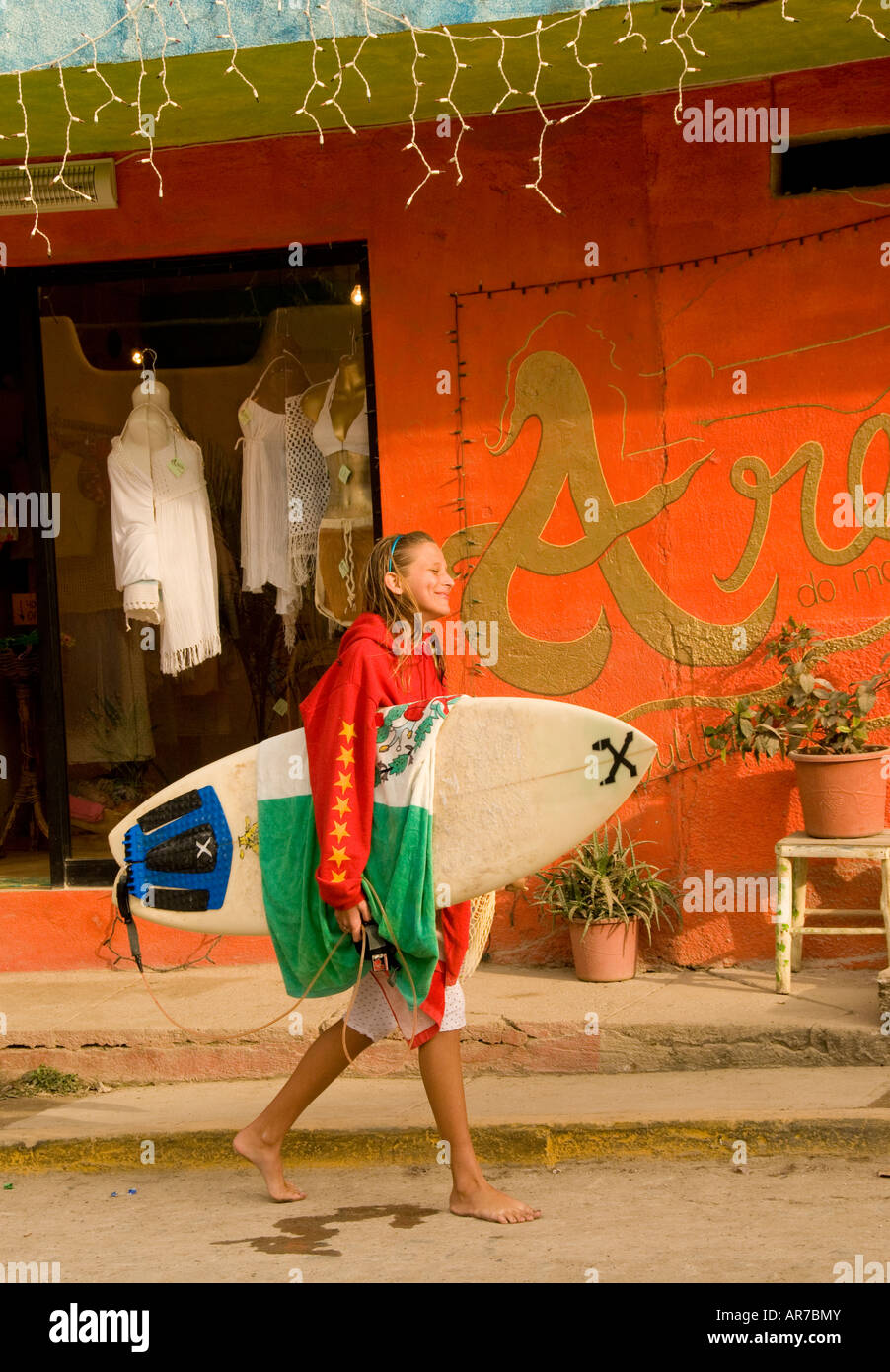 Mexico Riviera Nayarit Village of Sayulita near Puerto Vallarta on the Pacific Ocean young surfer girl walking by colorful shops Stock Photo