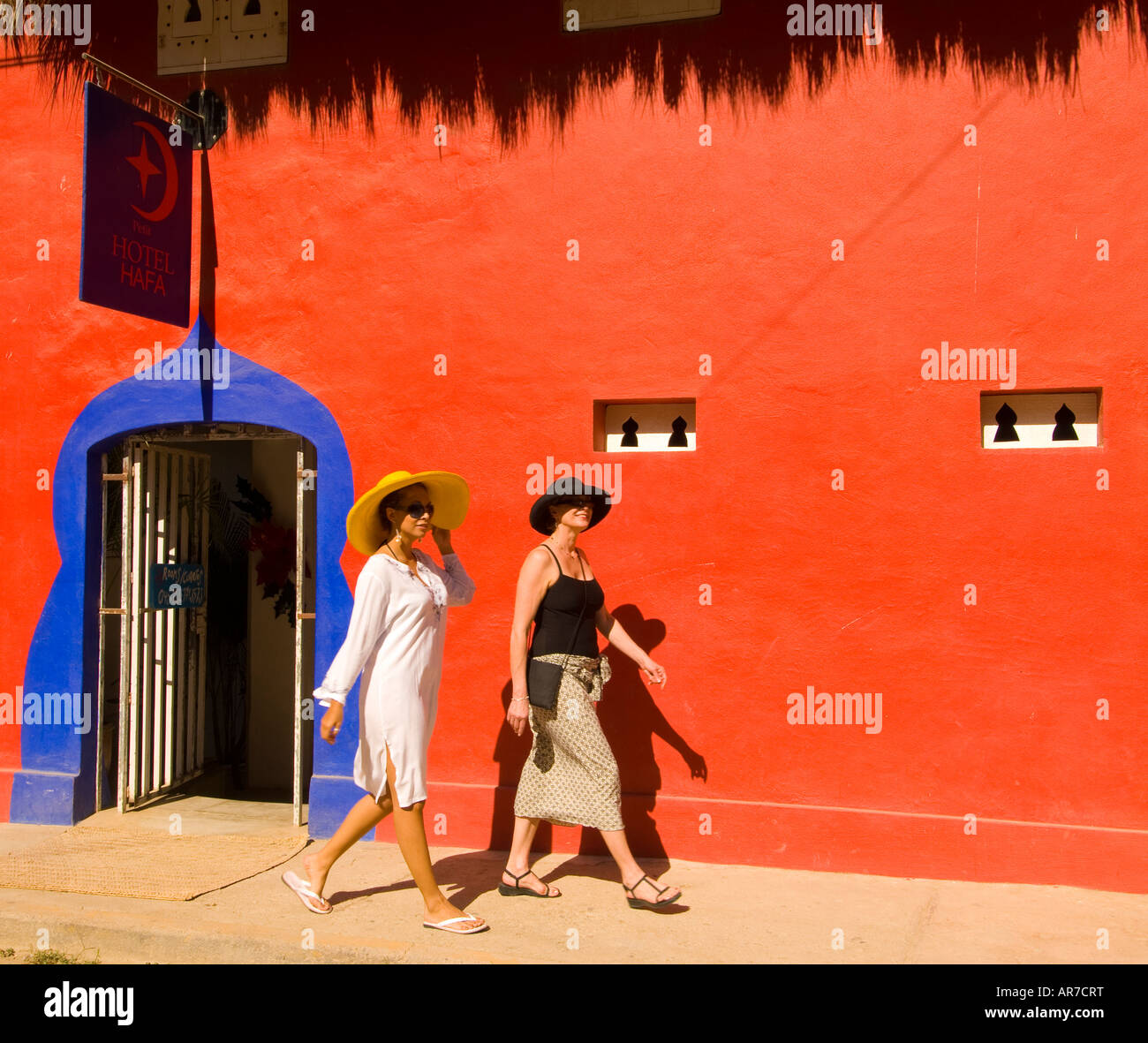 Mexico i Nayarit Village of Sayulita near Puerto Vallarta on the Pacific Ocean women walking next to colorful Hotel Petit d Hafa Stock Photo