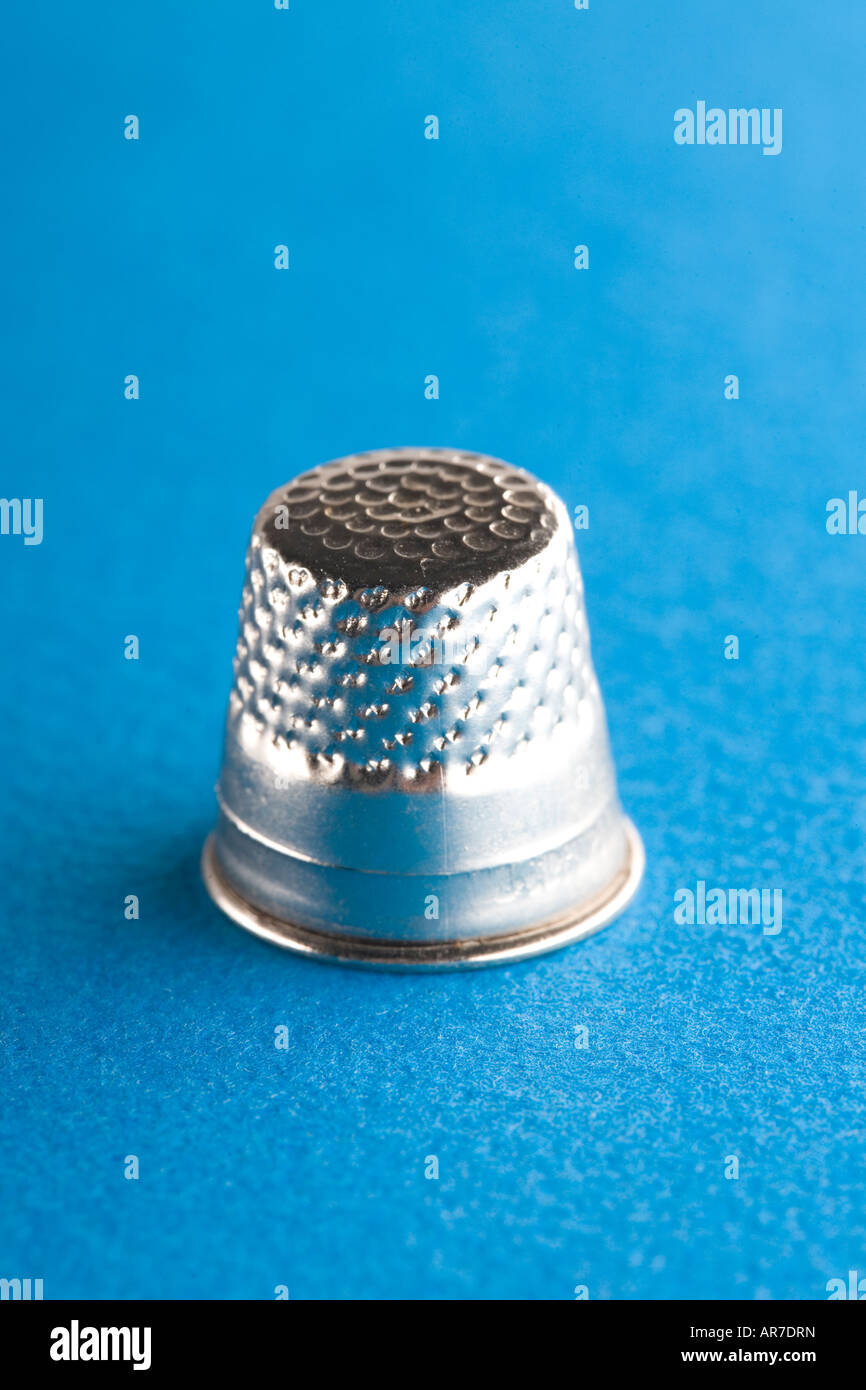 simple silver thimble on blue close up macro detail Stock Photo