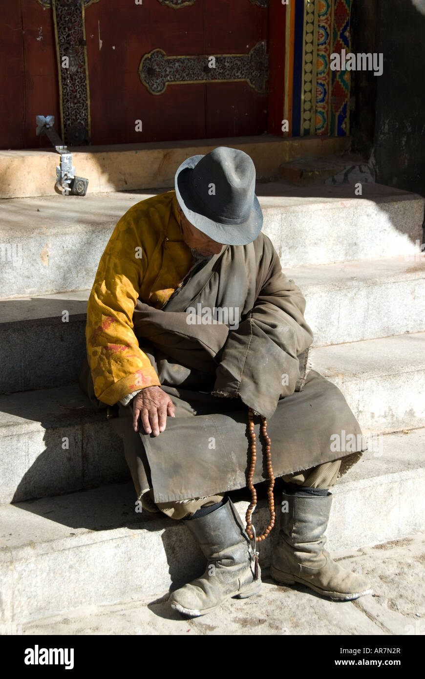 An exhausted Tibetan Pilgrim hangs his head in rest, Lhasa Tibet, The People’s republic of China Stock Photo