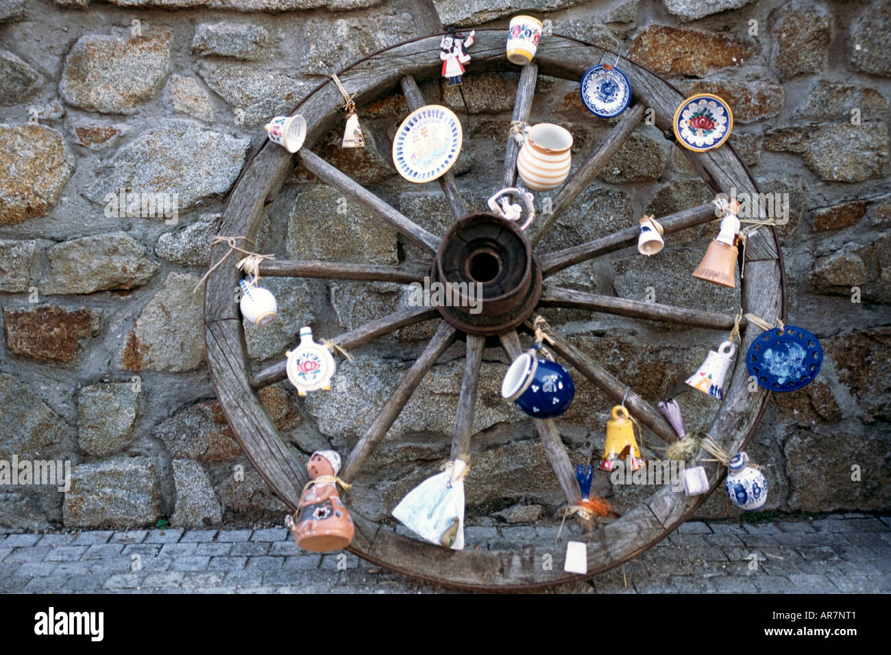 Assorted pottery ornaments hanging on an old wagon wheel in Bratislava, Slovakia. Stock Photo