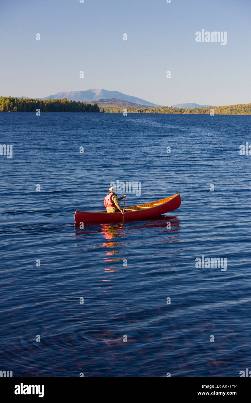 A man paddles his canoe on Seboeis Lake near Millinocket, Maine. Mount