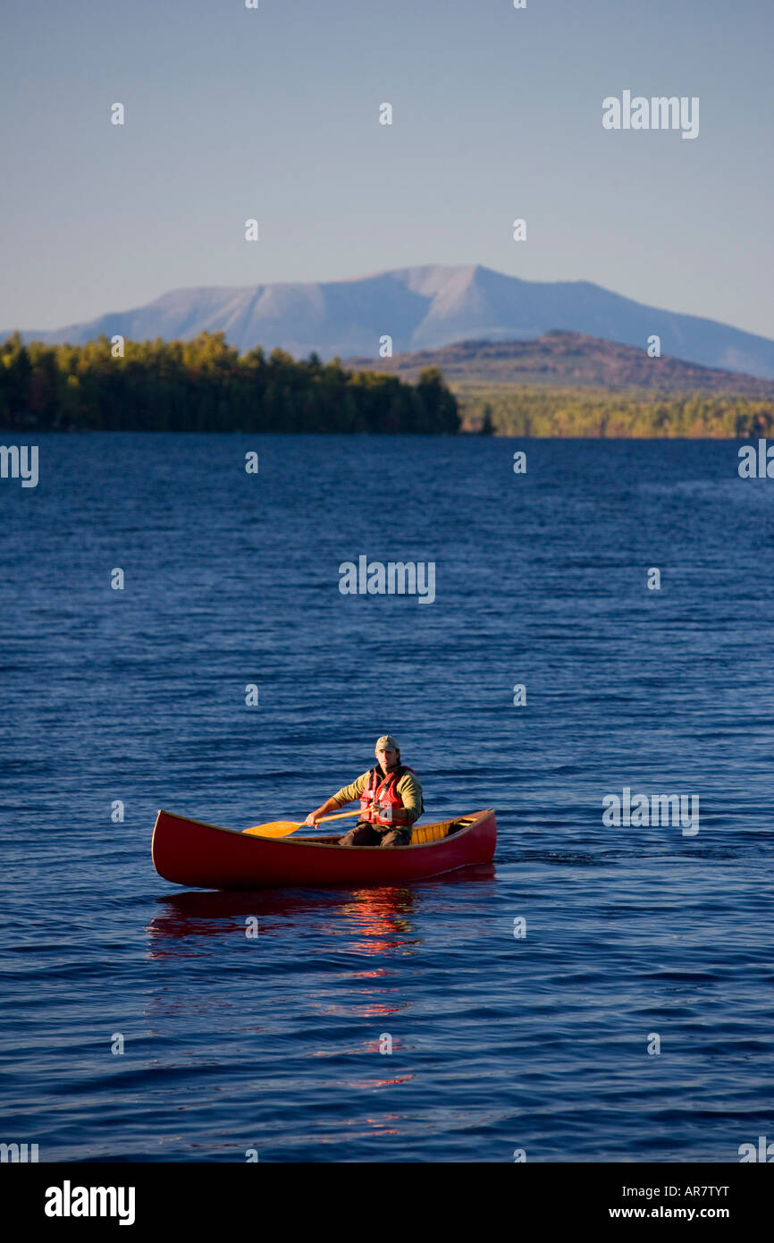 A man paddles his canoe on Seboeis Lake near Millinocket, Maine. Mount