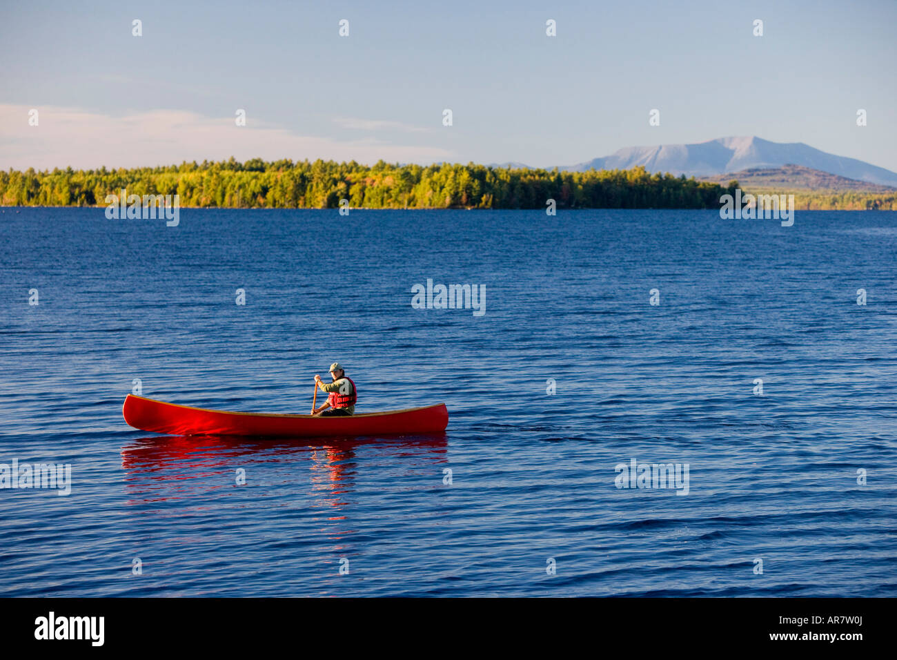 A man paddles his canoe on Seboeis Lake near Millinocket, Maine. Mount