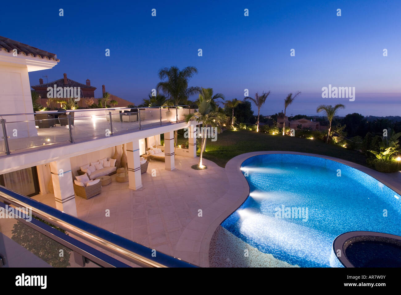 Spain, luxury villa terrace overlooking pool and seascape at dusk Stock Photo