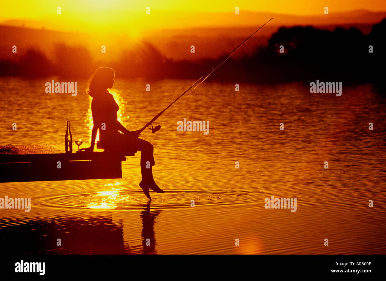 Girl fishing at sunset model released Stock Photo Alamy