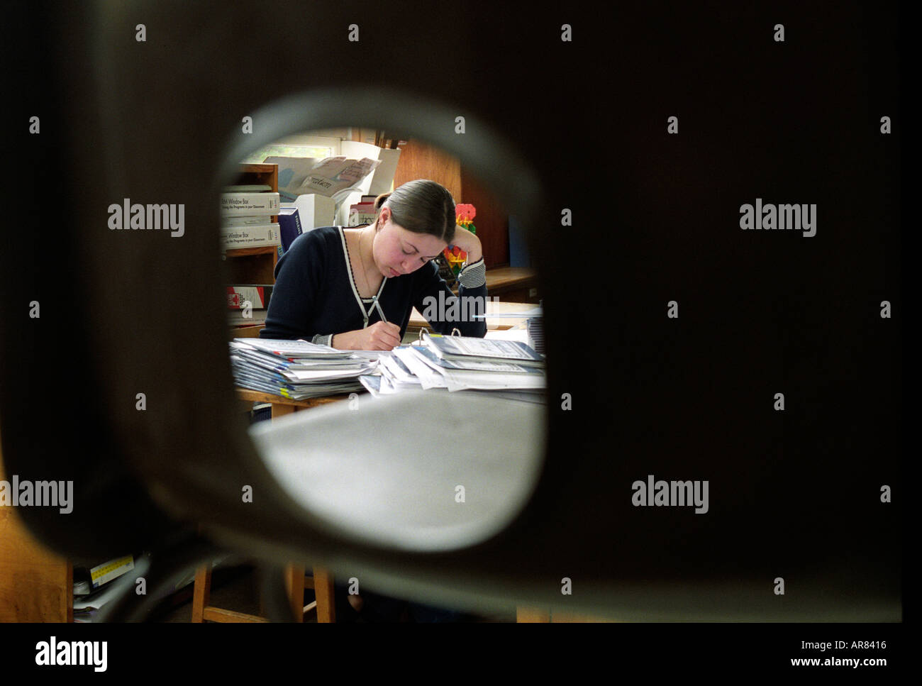 Teacher marking books after school. Stock Photo