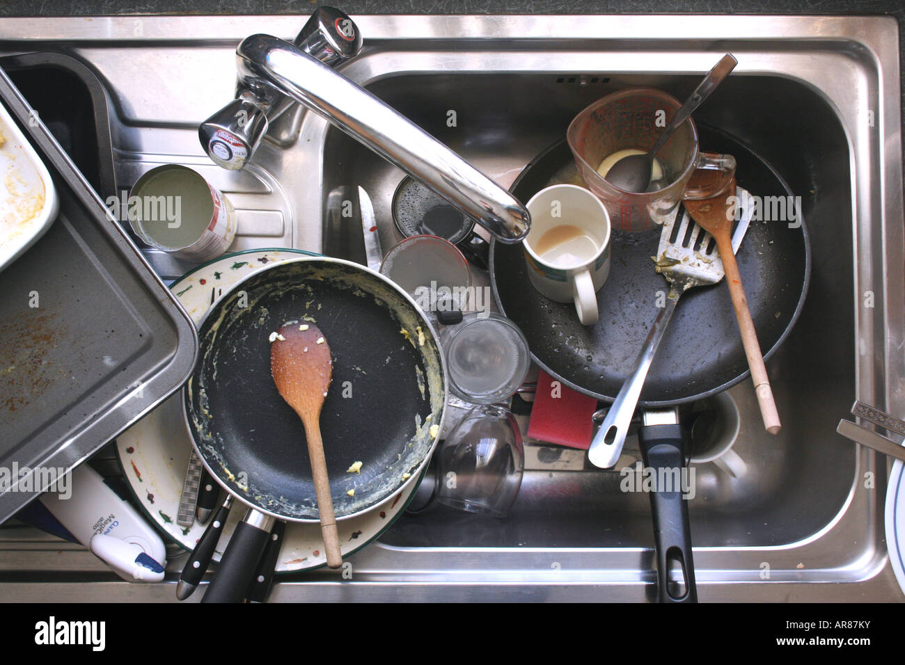 Kitchen sink full of dirty washing-up Stock Photo