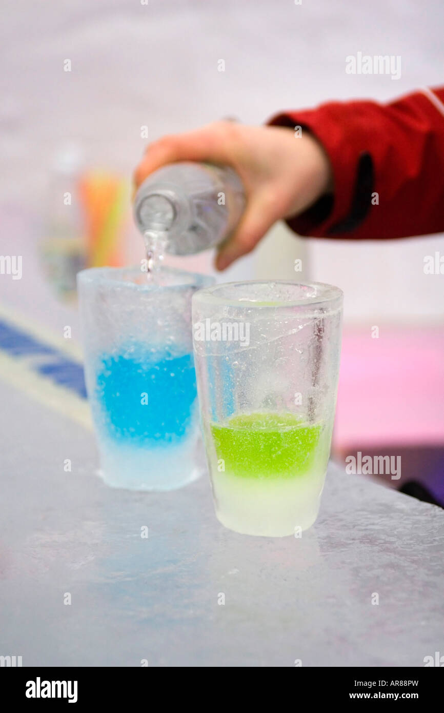 Pouring vodka into drinks shot glasses made of ice in an ice bar in Norway Stock Photo