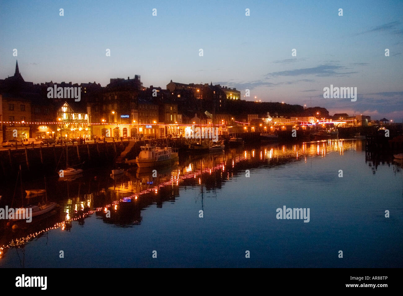 Whitby at dusk showing brightly lit amusement arcades and restaurants Stock Photo