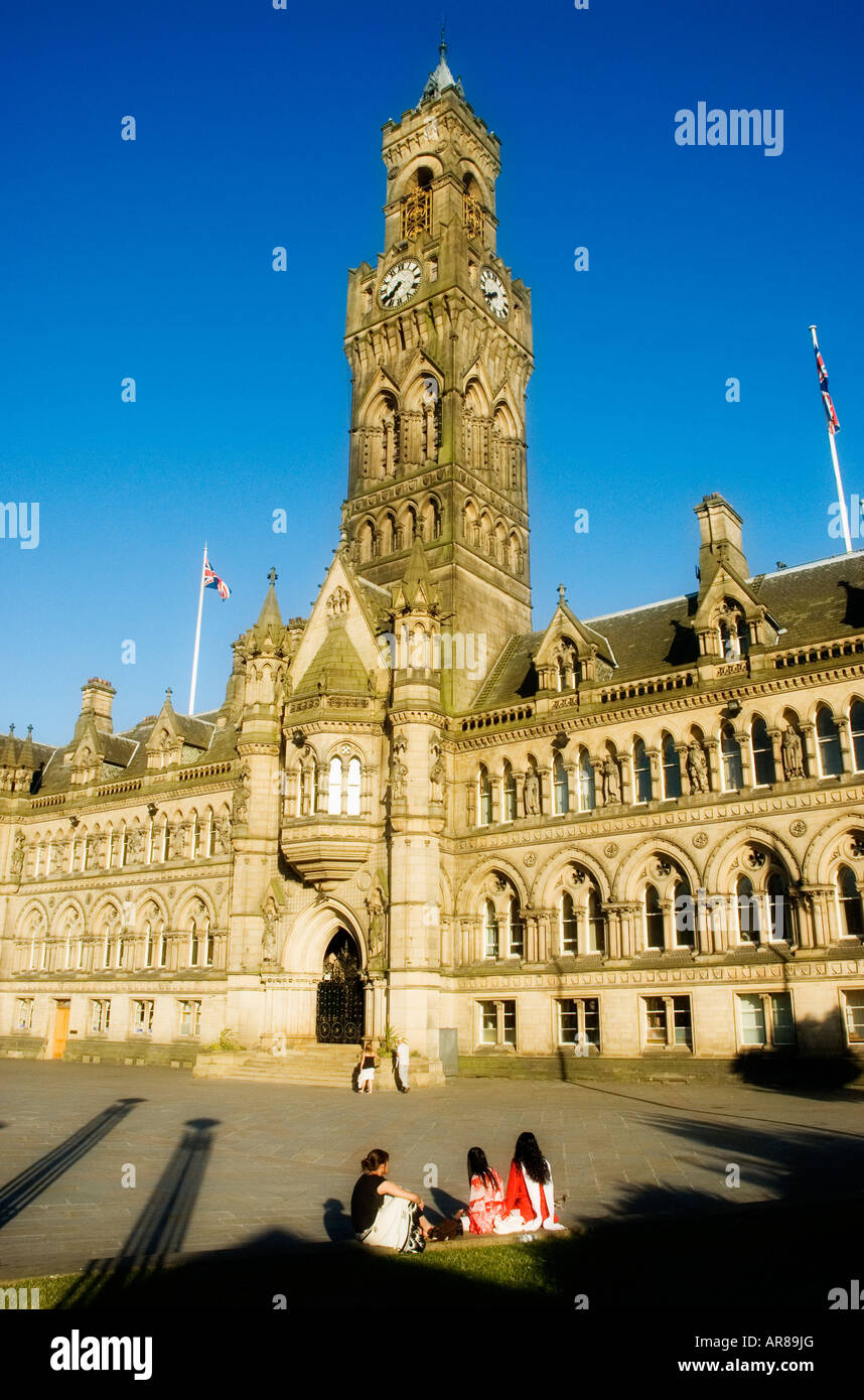 Bradford Town Hall with three asian women sat on the grass in front of the building Stock Photo