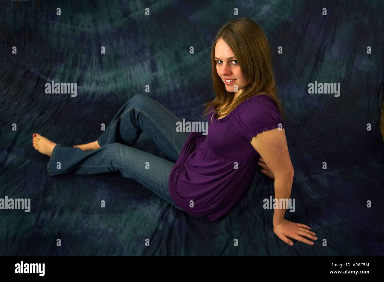 A young woman sitting on the ground Stock Photo - Alamy