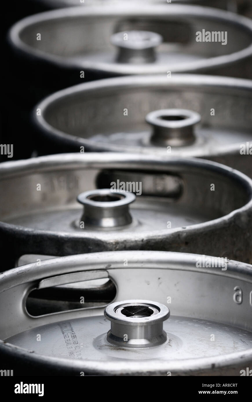 A line of empty aluminum beer kegs sitting on the street wait collection Stock Photo