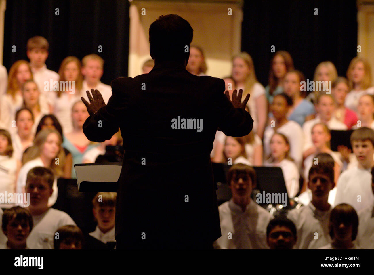 choir director directing teenage singers Stock Photo Alamy
