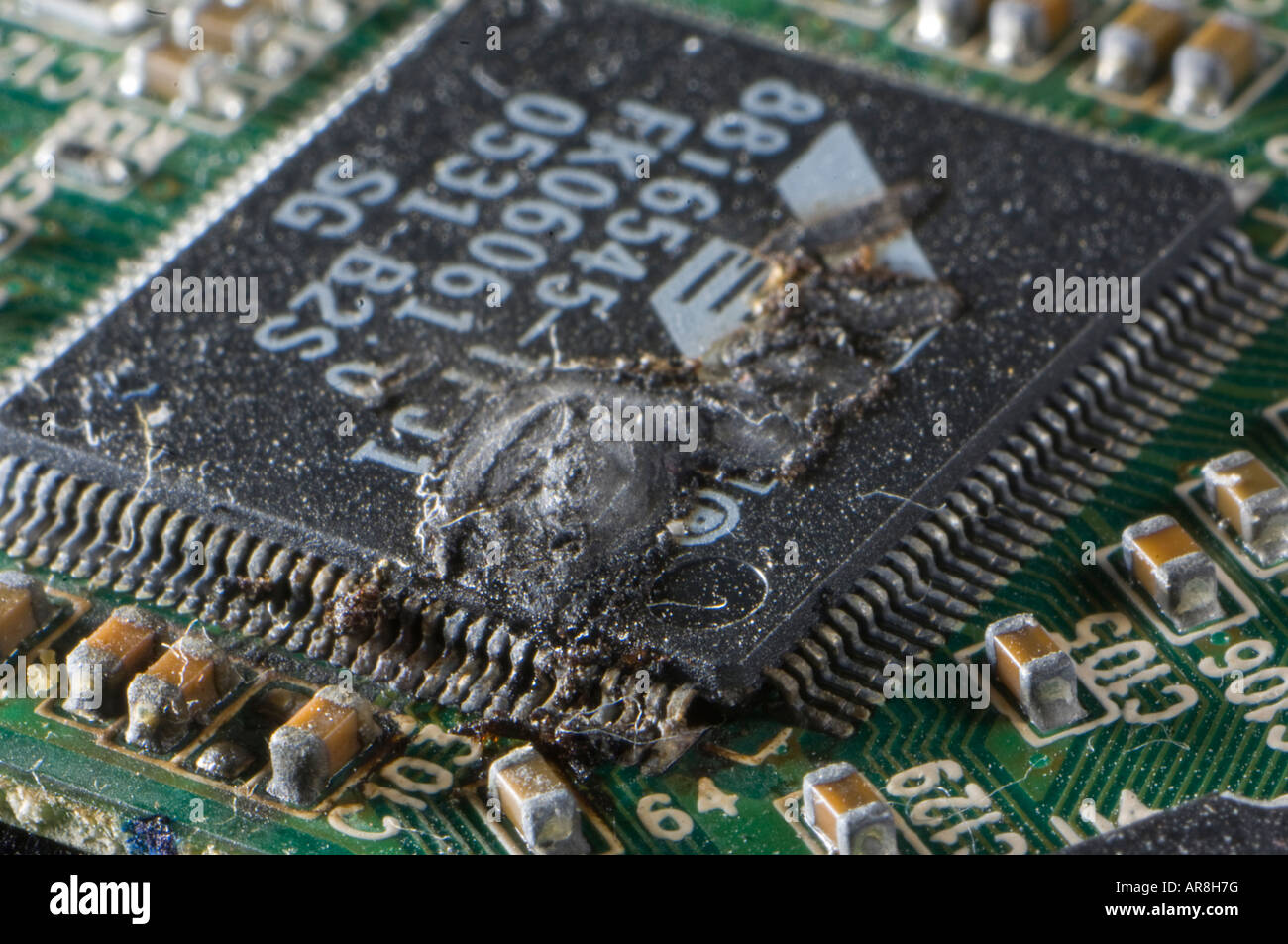 Burnt integrated circuit controller on an electronic board due to a surcharge Stock Photo