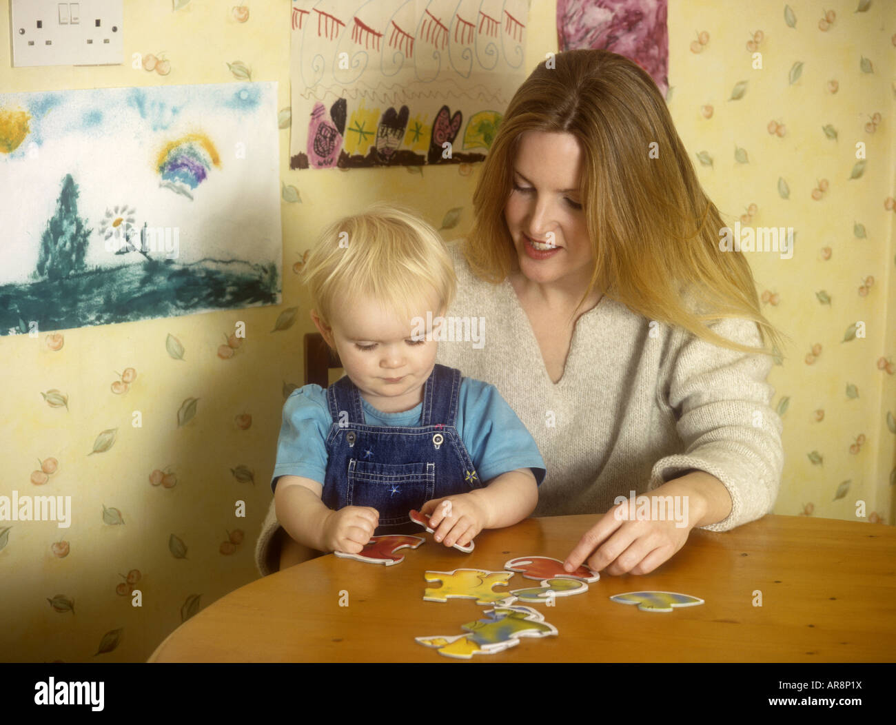 Mother doing jigsaw with baby Stock Photo Alamy