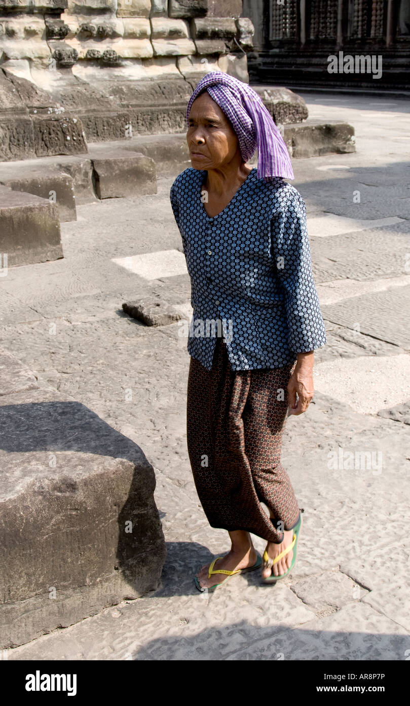 Elderly lady walks across a courtyard of Angkor Wat Stock Photo