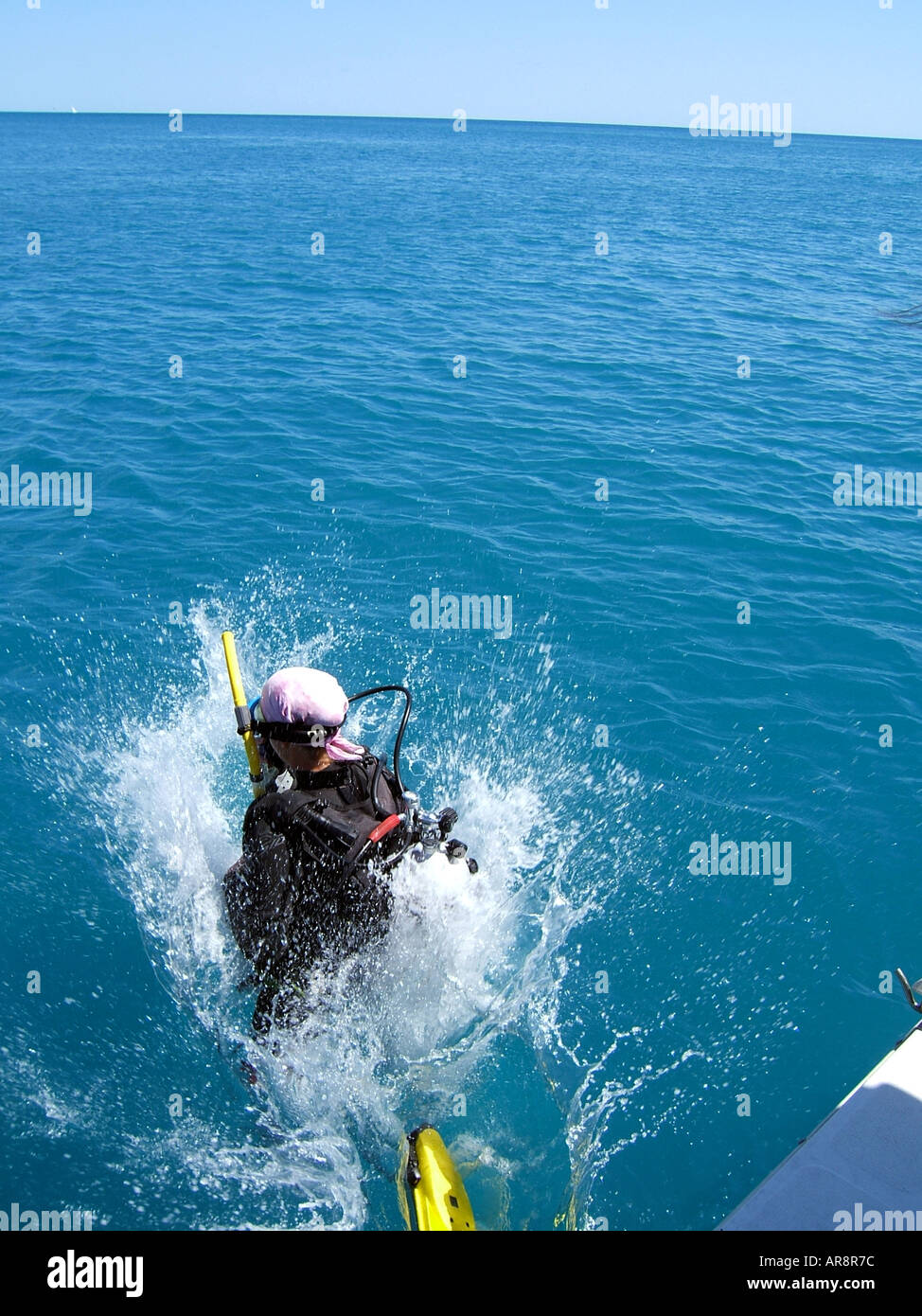 Scuba diver jumping into the water from a dive boat.Coastal waters Sydney Australia Stock Photo
