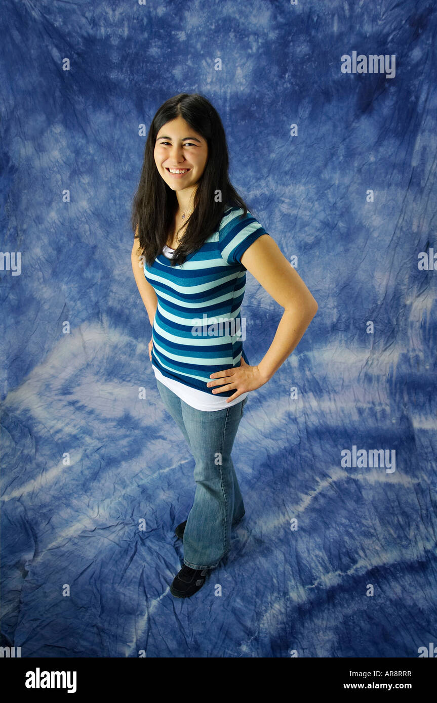 Young asian american woman with hands on hips shot from above on a blue background Stock Photo