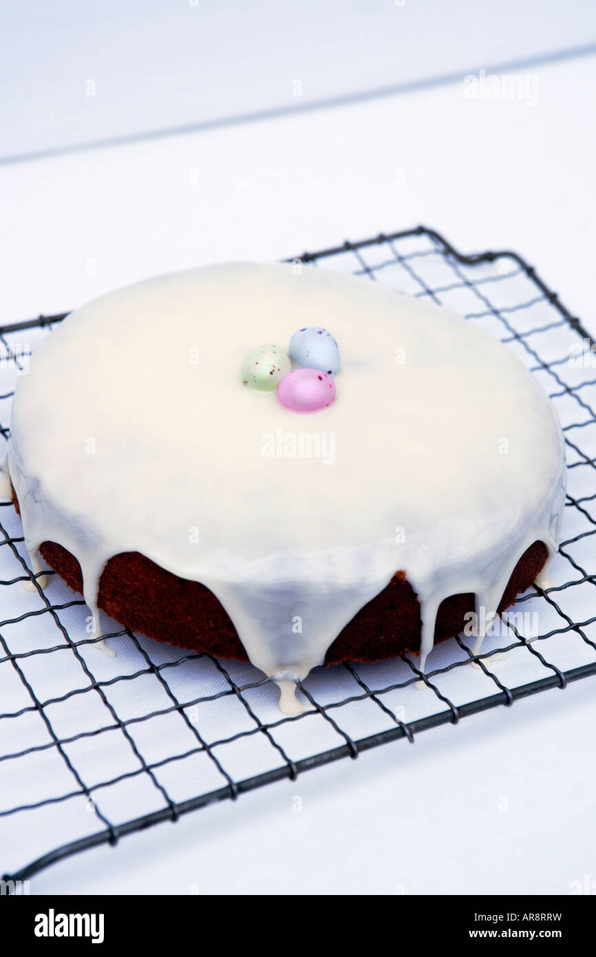 Home baked Easter cake with fondant icing and finished with sugar coated chocolate easter eggs served on baking tray. Stock Photo