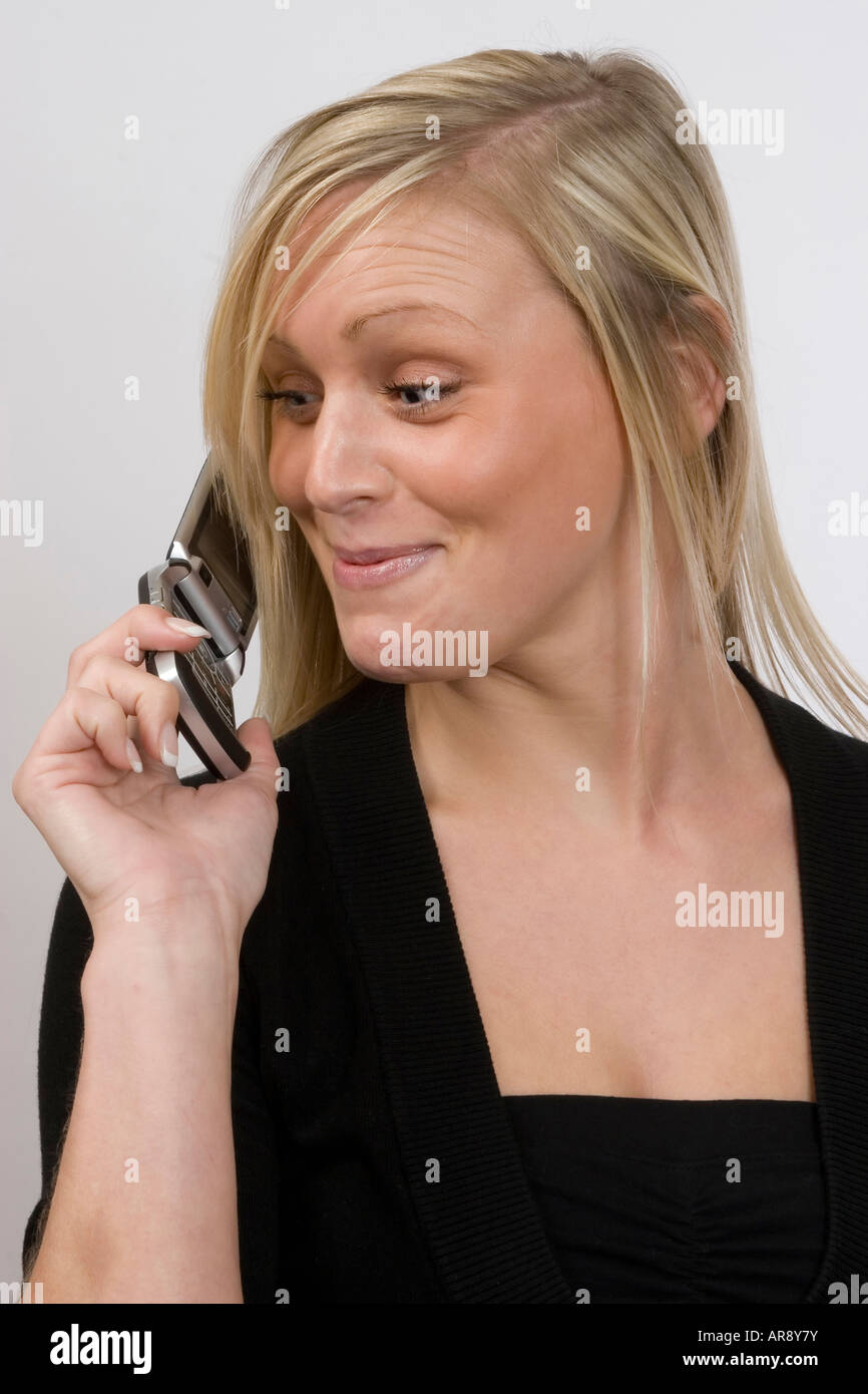 Woman using mobile phone reacting with amused surprise. Stock Photo