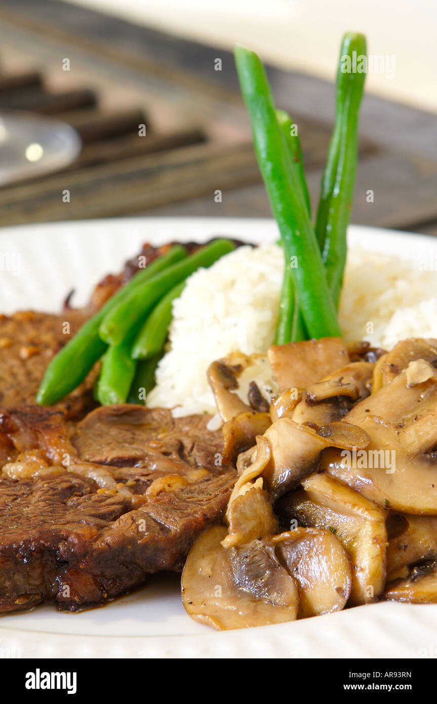 Cooked Ribeye meal rice green beans and mushrooms close up low level ...