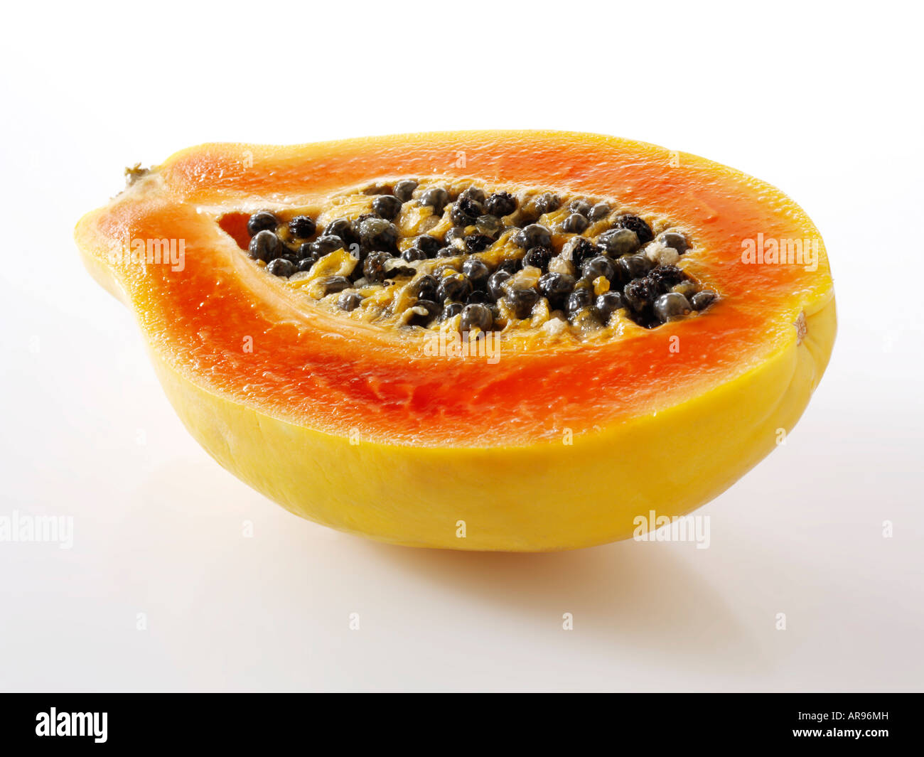 papaya tropical fruit cut in half against a white background as a cut out Stock Photo