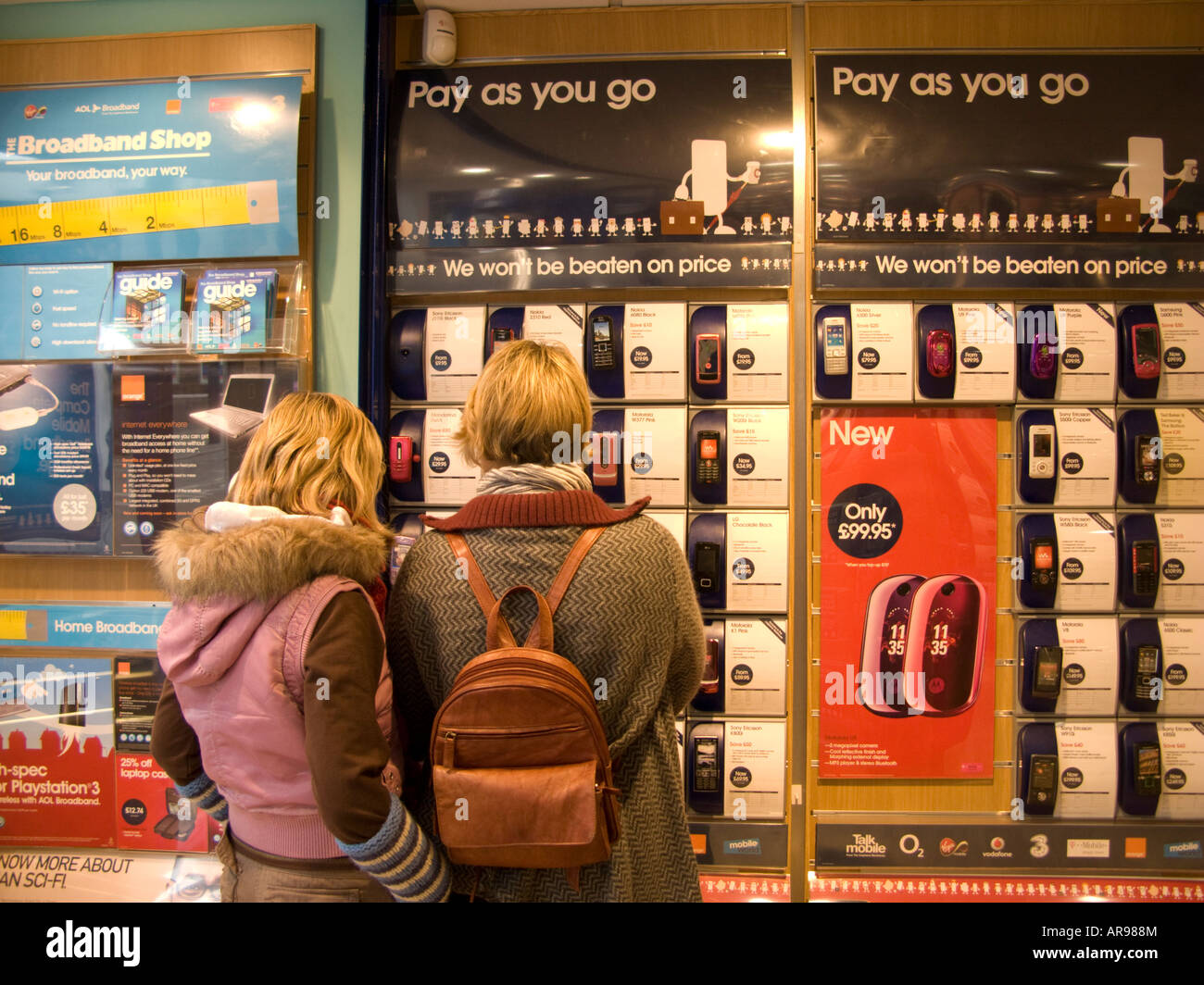 UK Carphone Warehouse Mother and teenage daughter looking at mobile phone handsets deciding which one to buy for the girl Stock Photo