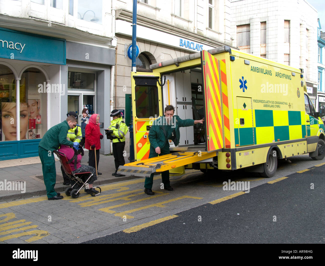 Ambulance service helping elderly woman who had fallen in the street