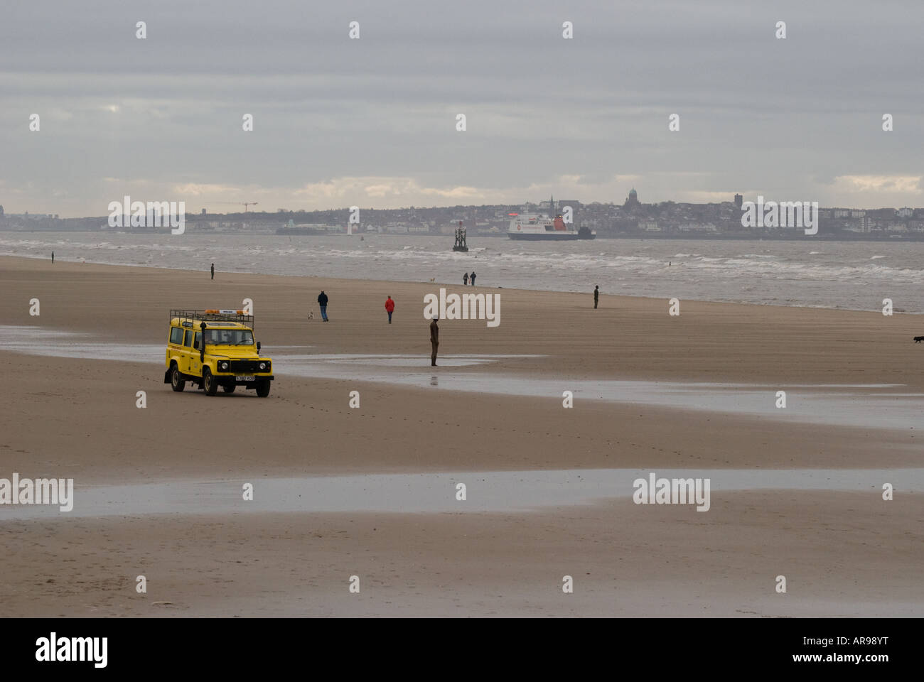 Statues, people and sea rescue on Crosby Beach, Merseyside, UK Stock