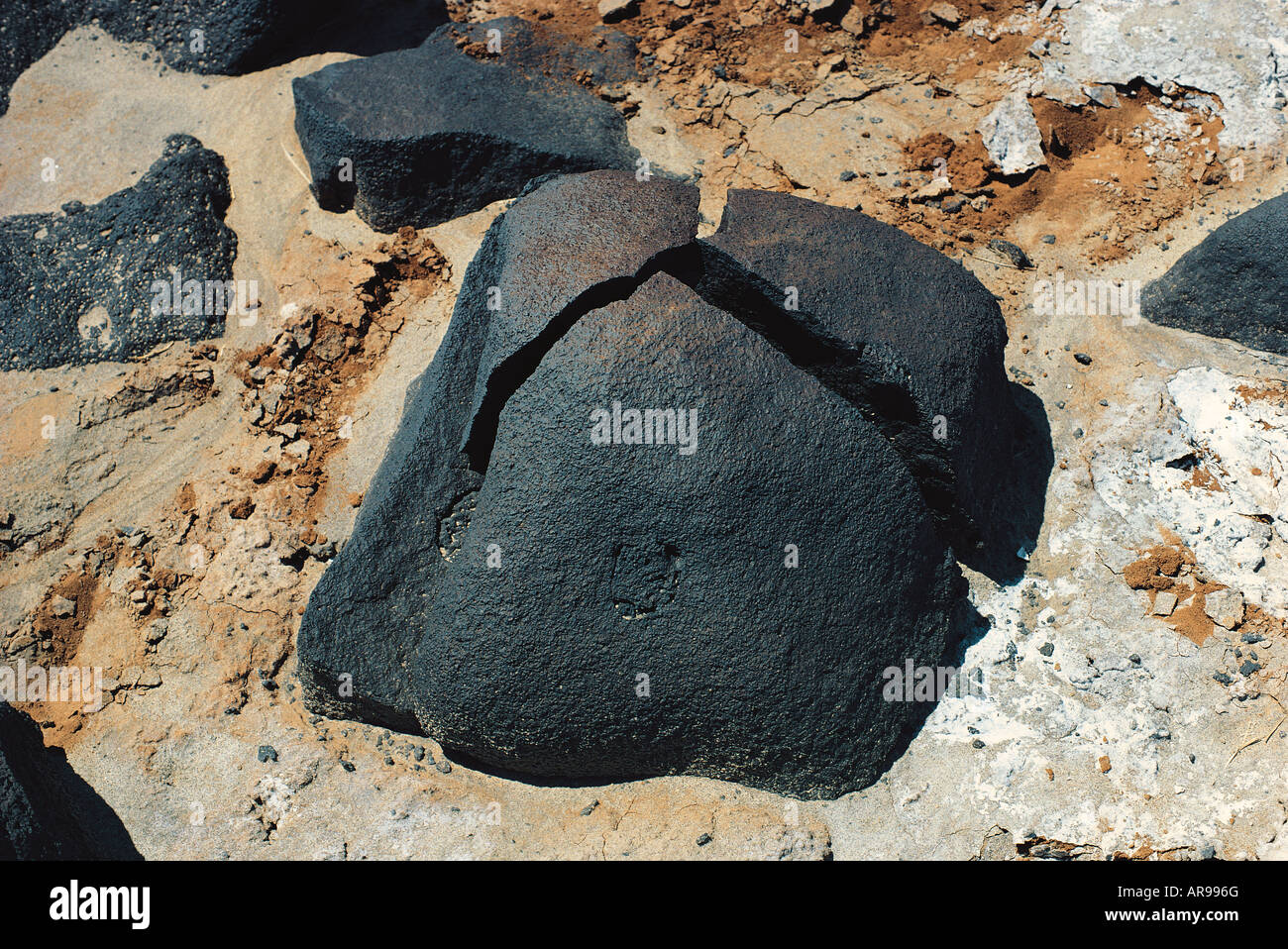 Black lava boulder split into three pieces by expansion and contraction Chalbi Desert in northern Kenya East Africa Stock Photo