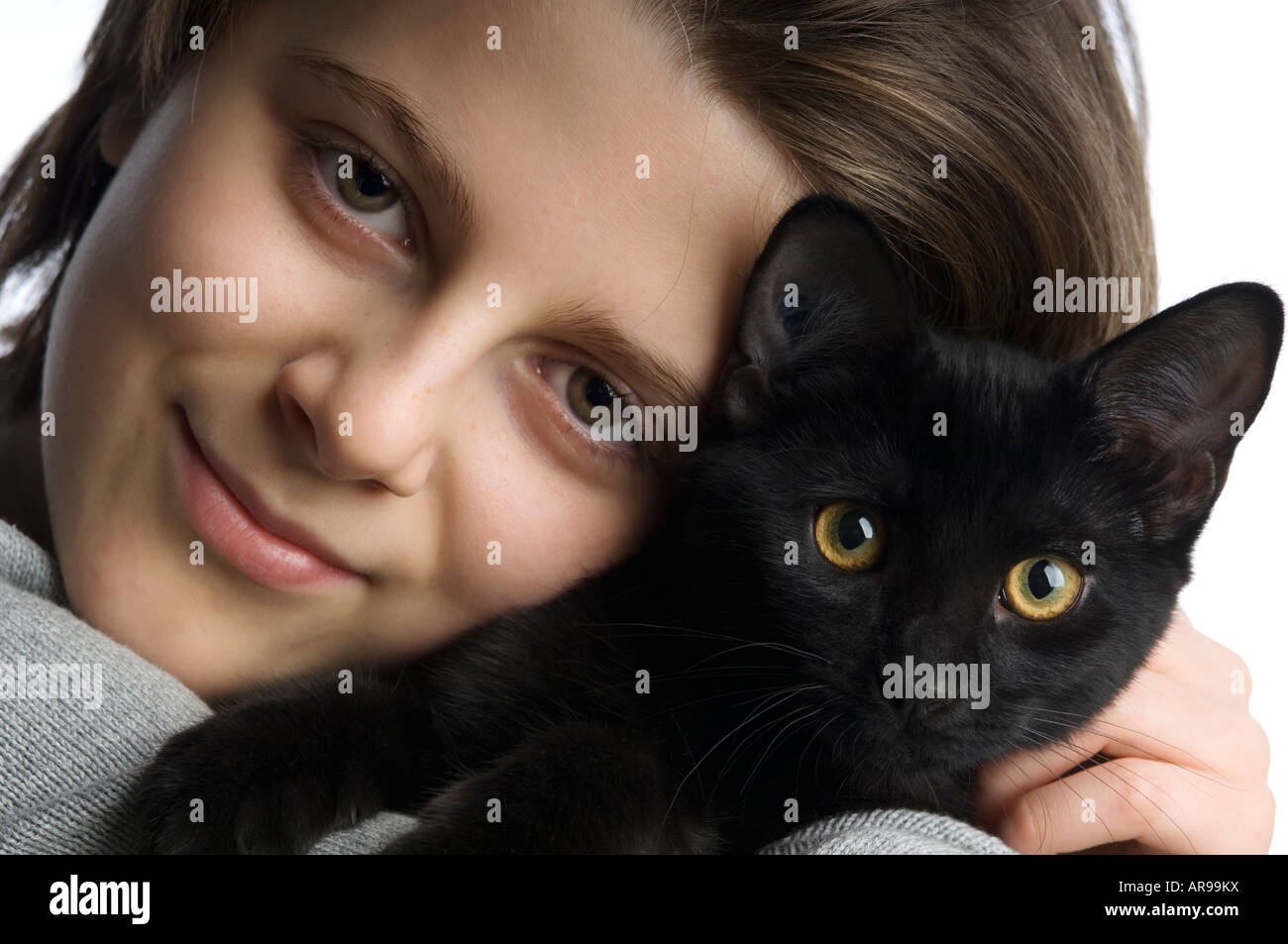 studio close up portrait of a young girl and a black kitten Stock Photo