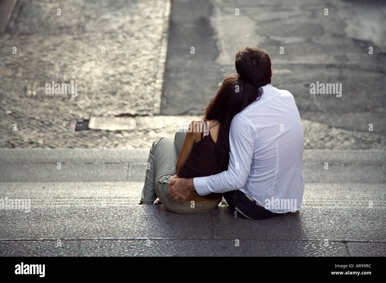 A young couple in love embrace on steps in Rome Stock Photo
