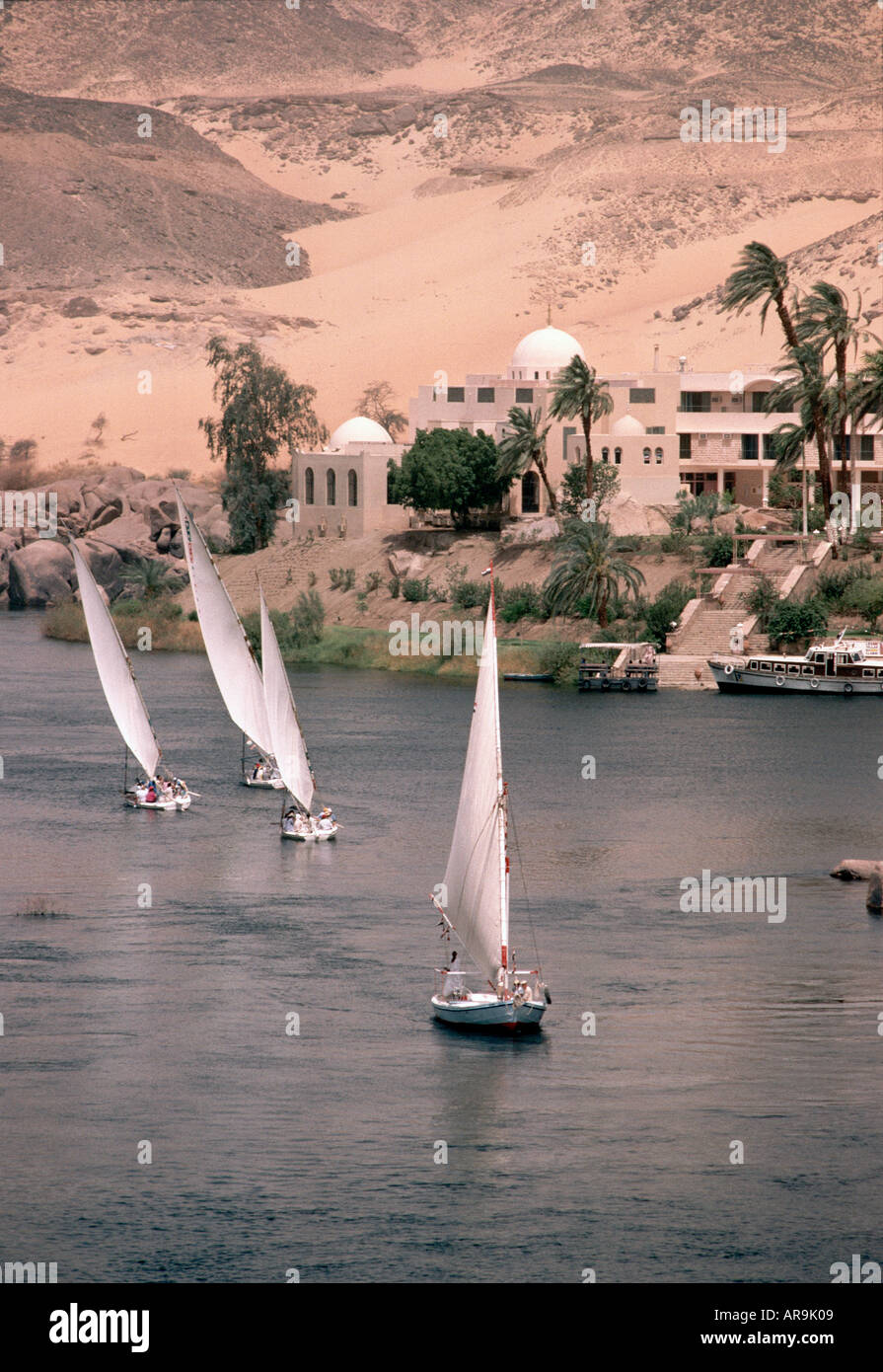 Aswan, Egypt, Africa,  River Nile with feluccas sailing boats desert sand dunes travel near the Aga Khans mausaleum Stock Photo