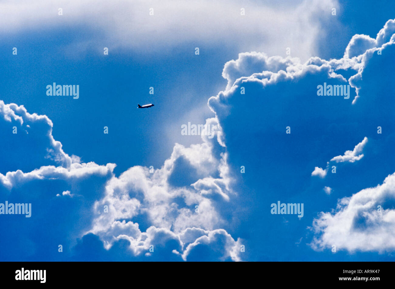 Airbus A320 jet airliner flying at high altitude between clouds Stock Photo
