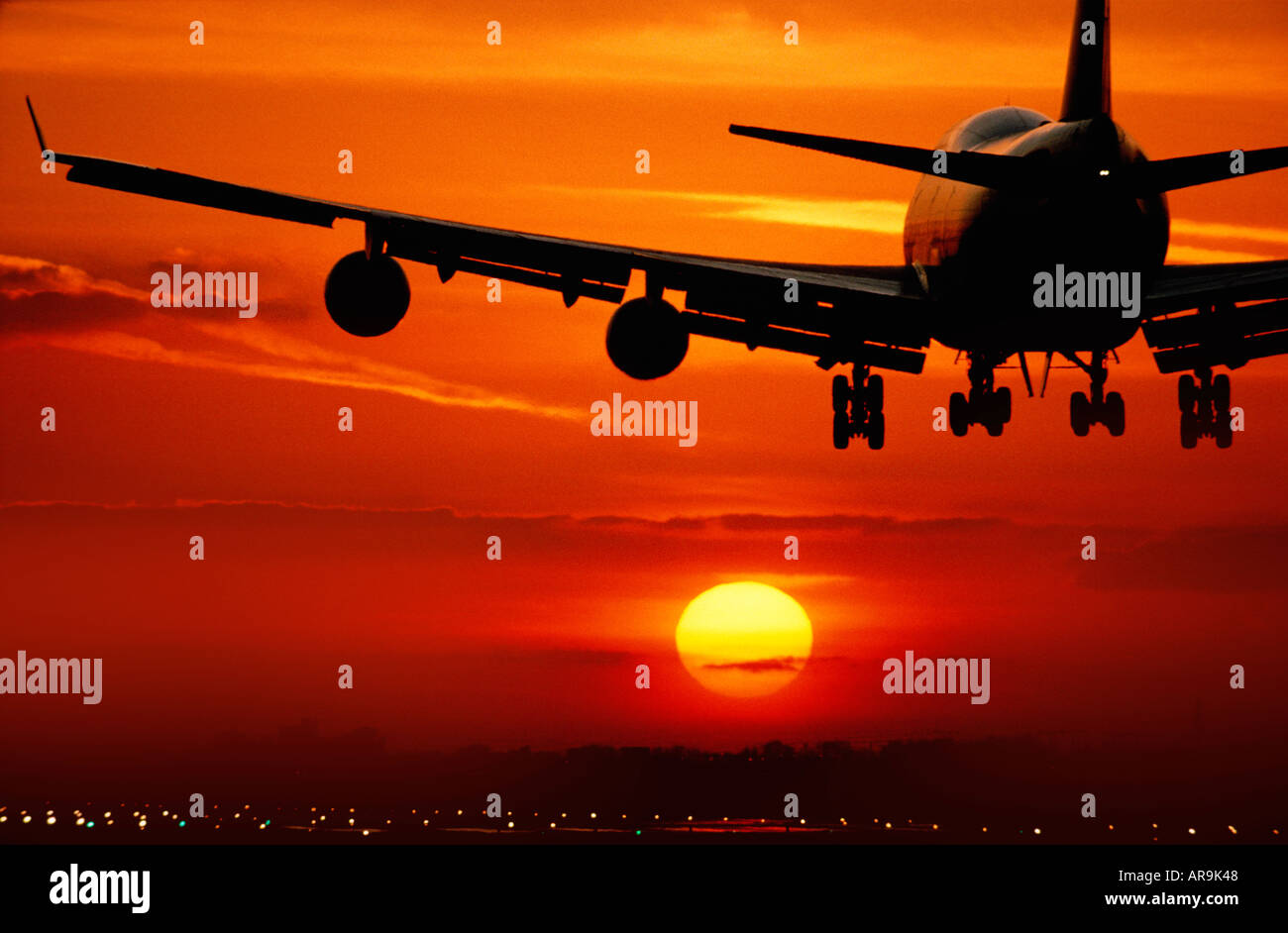 Boeing 747 jumbo jet airliner flying landing in an golden orange cloud sky at sunset Stock Photo