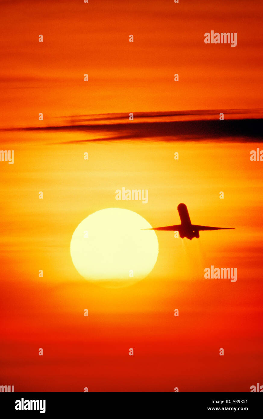 jet airliner flying up towards sunset Stock Photo