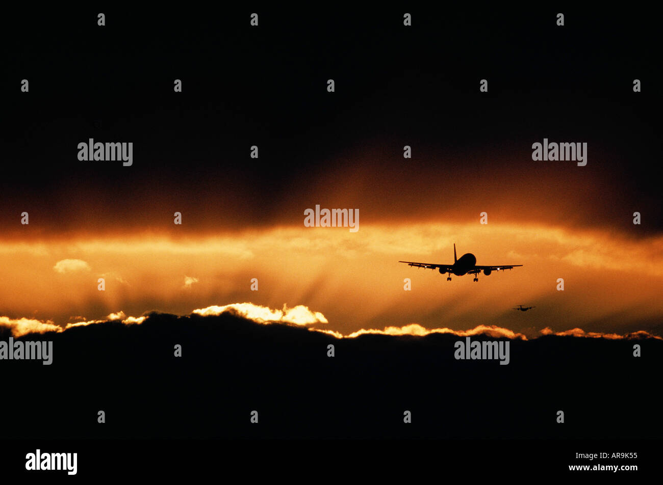 Airbus jet airliner flying at sunset sunburst Stock Photo