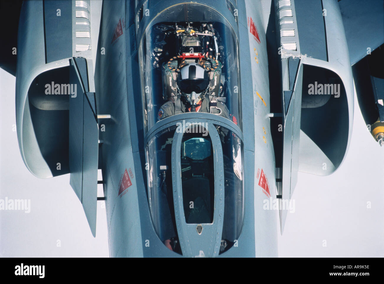 USAF F-4E Phantom supersonic jet fighter bomber at high altitude with pilot in cockpit and engine intakes windshield Stock Photo