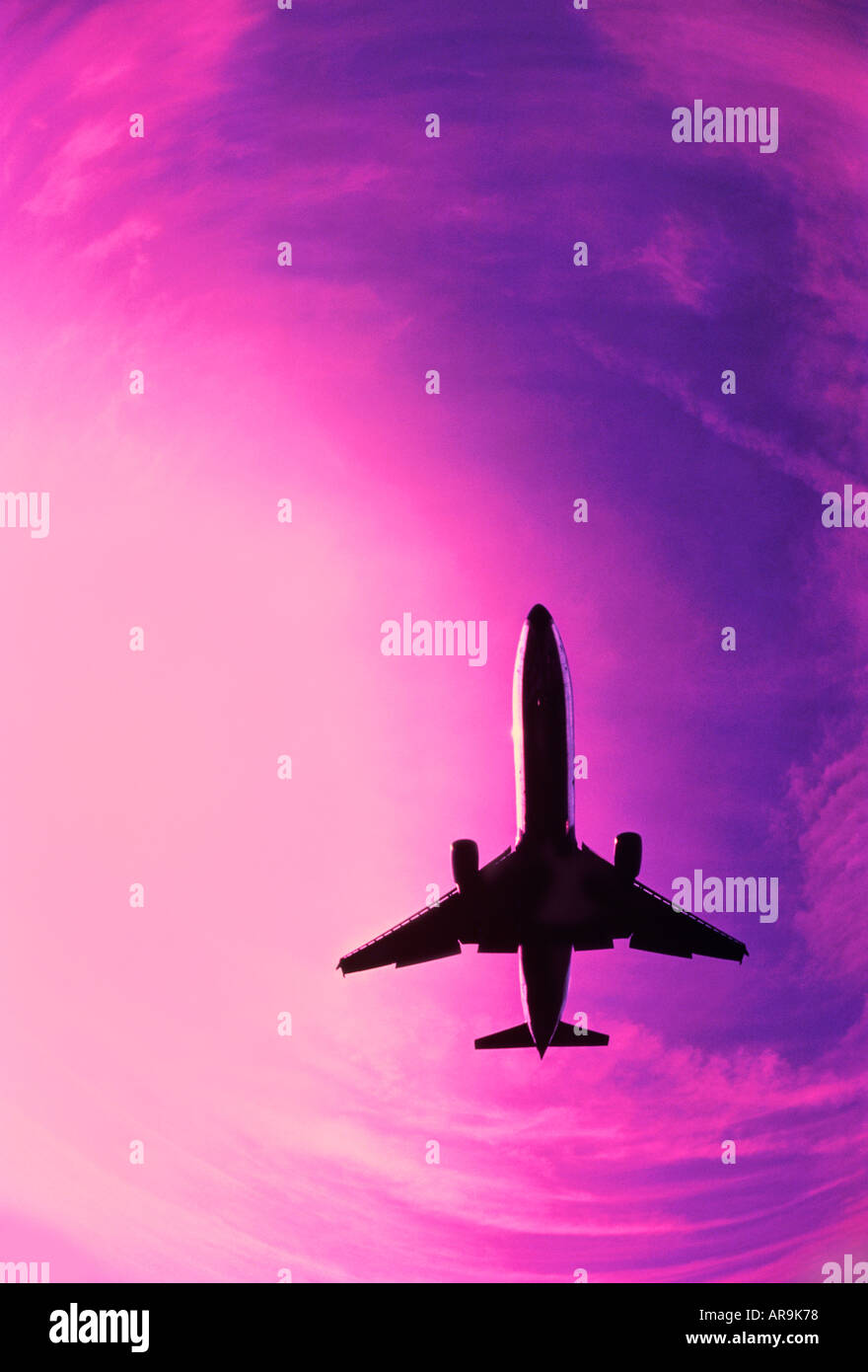 Boeing MD-11 jumbo jet airliner pink purple sky at cruising altitude aero engines wings Stock Photo