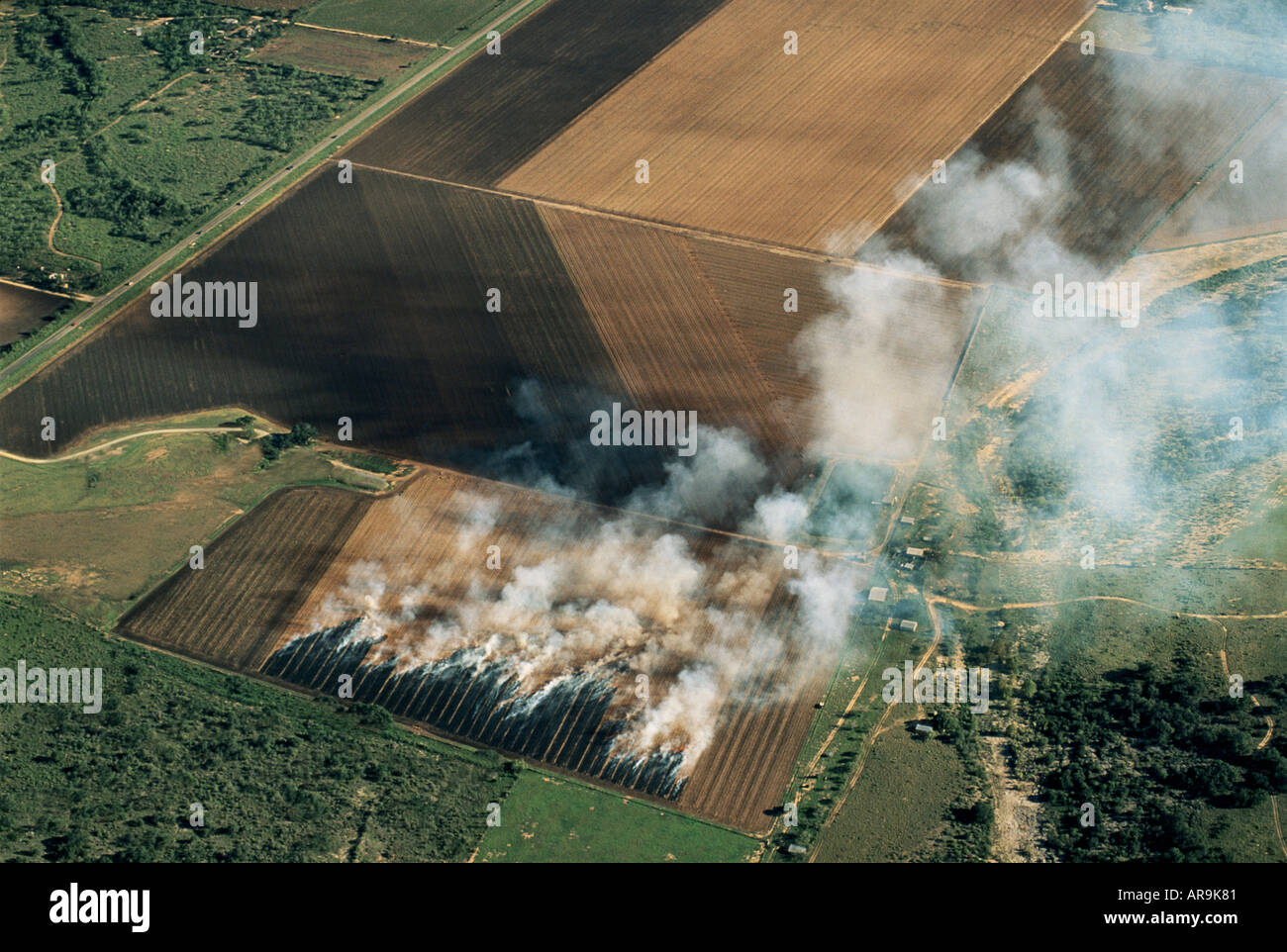 aerial view of farming agriculture burning fire on fields of crops slash and burn stubble smoke aerial view from above Stock Photo