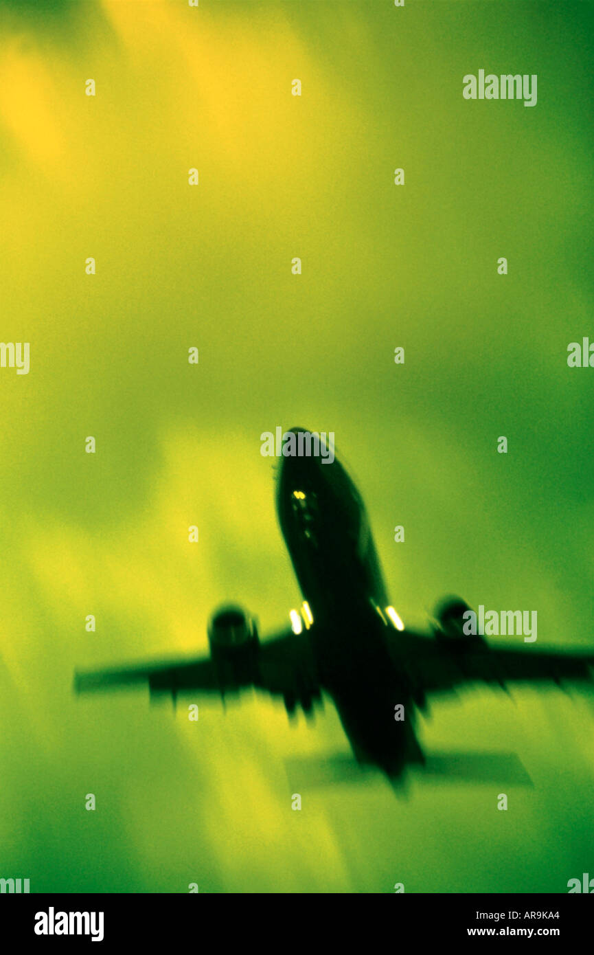 Boeing 737 in the air flying into green cloudy sky at dusk showing jet thrust exhaust pollution silhouette colour Stock Photo