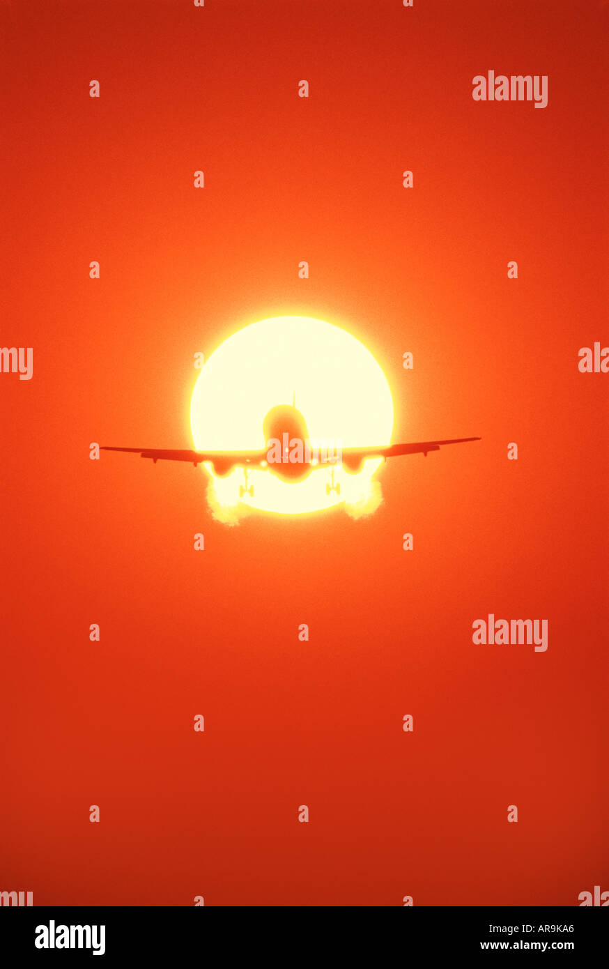 Boeing 757 jet airliner in the air flying in a golden orange ball of fire sky at sunset Stock Photo