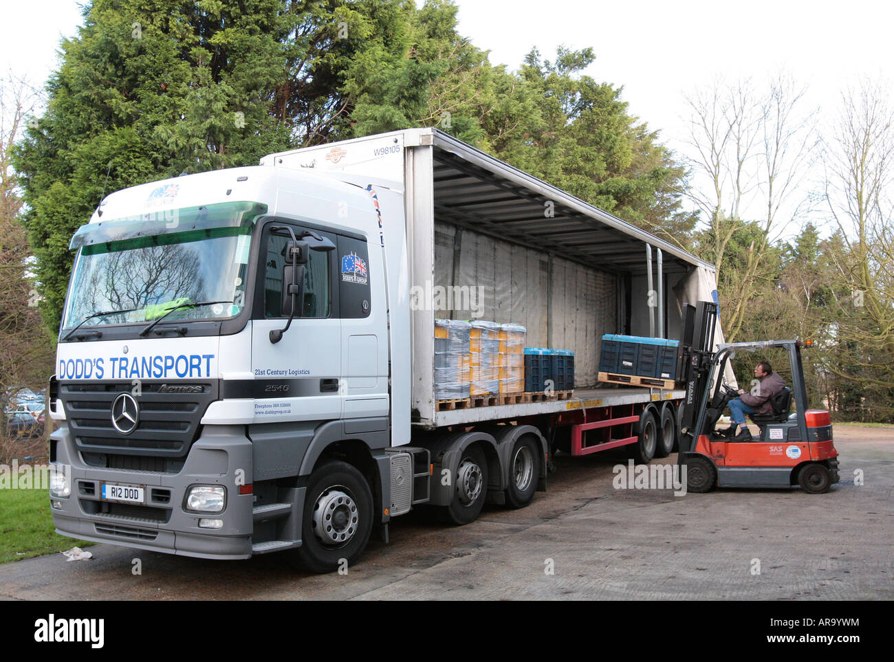 A forklift driver loads a pallet of diesel engine components into a