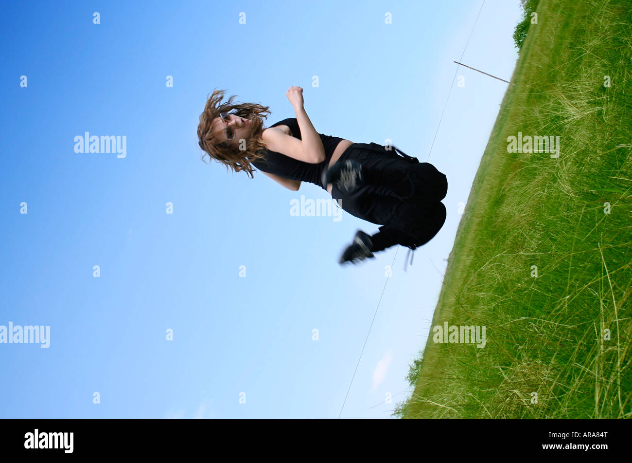Happy woman jumping against blue sky Stock Photo - Alamy
